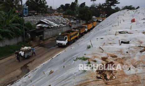 Pekerja membawa sampah menggunakan gerobak melintasi plastik yang menutup tumpukan sampah di TPA Cipayung, Depok, Jawa Barat, Jumat (6/2/2020). Dinas Lingkungan Hidup dan Kebersihan (DLHK) Kota Depok menyiagakan 40 unit truk sampah dan 125 petugas kebersihan atau pesapon selama libur lebaran 2022.