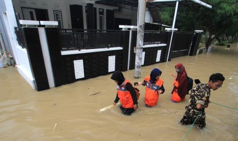  (ilustrasi)Warga melintasi banjir yang merendam di desa Wanakaya, Kecamatan Gunungjati, Cirebon, Jawa Barat (ilustrasi)