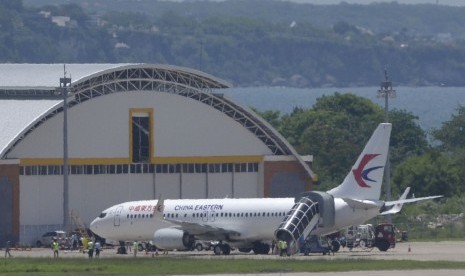 Sejumlah petugas berada di sekitar pesawat milik maskapai penerbangan China Eastern di area apron Bandara Internasional I Gusti Ngurah Rai, Bali, Sabtu (8/2/2020).