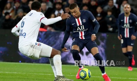  Pemain PSG Kylian Mbappe berusaha melewati pemain Lyon Marcelo (kiri) pada lanjutan pekan ke-24 Ligue 1 di Stadion Parc des Princes, Paris (9/2). Kompetisi Ligue 1 dan Ligue 2 tak bisa digelar sampai setidaknya September.