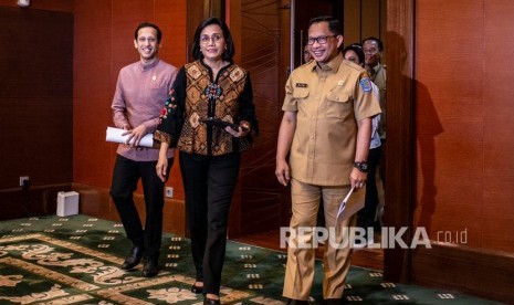 Menkeu Sri Mulyani (tengah) bersama Mendikbud Nadiem Makarim (kiri) dan Mendagri Tito Karnavian (kanan) bersiap memberikan konferensi pers tentang Sinergi Pengelolaan Dana Bantuan Operasional Sekolah (BOS) dan Dana Desa Berbasis Kinerja di Kementerian Keuangan, Jakarta, Senin (10/2/2020). 