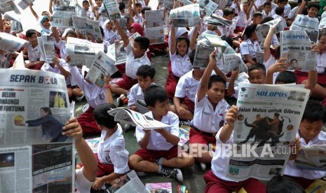 Sejumlah siswa SD Negeri Tugu Solo mengikuti kegiatan membaca koran bersama di halaman sekolah setempat, Solo, Jawa Tengah, Selasa (11/2/2020).Pemerintah ganti skema penyaluran dana BOS langsung dari pemerintah pusat kepada rekening sekolah.  