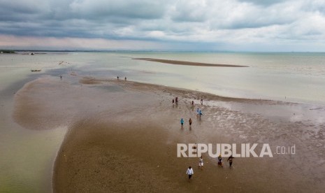 Sejumlah wisatawan menikmati suasana pantai yang terbentuk dari fenomena akresi (penambahan garis pantai dari darat menuju laut akibat sedimentasi bertahun-tahun) di Desa Surodadi, Sayung, Demak, Jawa Tengah, Selasa (11/2/2020). 