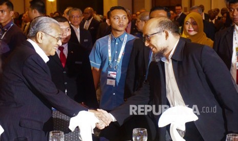 Perdana Menteri Malaysia Tun Dr Mahathir Mohamad berjabat tangan dengan penyelidik Komisi Pemberantasan Korupsi (KPK) Novel Baswedan saat menghadiri peluncuran Perdana International Anti-Corruption Champion Fund (PIACCF) di Putrajaya, Malaysia, Selasa (11/2/2020).