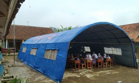 Para siswa SDN 3 Cigorowong, Kabupaten Tasikmalaya, belajar di tenda darurat, Rabu (12/2). Sejumlah siswa lainnya mesti belajar di atas lantai beralaskan karpet dalam ruang kelas.Proses KBM dipindahkan ke tenda darurat dilakukan sejak Selasa (11/2). 