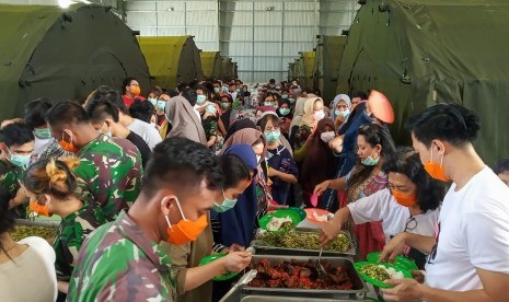 Sejumlah Warga Negara Indonesia (WNI) yang dievakuasi dari Wuhan, China mengambil makan di pusat observasi di Hanggar Pangkalan Udara TNI AU Raden Sadjad, Ranai, Natuna, Kepulauan Riau, Rabu (12/2/2020).