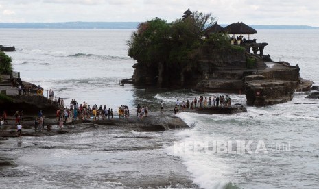 Wisatawan beraktivitas di Pantai Tanah Lot, Tabanan, Bali, Ahad (16/2). Lesunya pariwisata Bali telah membuat hotel melakukan pengaturan jam kerja. 