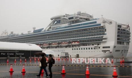 Pengunjung berjalan melewati kapal pesiar Diamond Princess yang dikarantina pada hari Ahad, (16/2), di Yokohama, dekat Tokyo. 