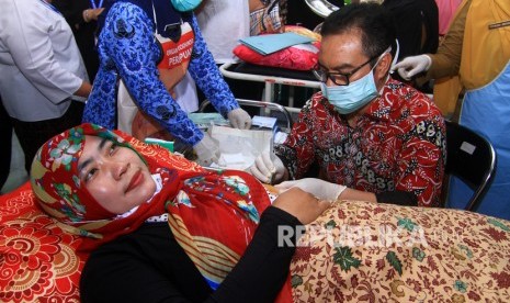 Kepala Badan Kependudukan dan Keluarga Berencana Nasional (BKKBN) Hasto Wardoyo (kanan) memasang alat kontrasepsi jangka panjang jenis implant di tangan warga akseptor di Puskesmas Singkawang Barat 1 di Singkawang, Kalimantan Barat, Senin (17/2/2020).