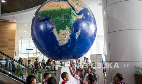 Pelajar mengamati Globe di Perpustakaan Nasional, Jakarta, Selasa (18/2/2020).