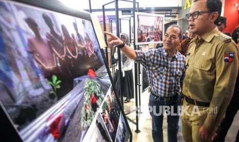 Wali Kota Bogor Bima Arya (kanan) mendengarkan penjelasan foto dari kurator Pewarta Foto Senior Antara Hermanus Prihatna (kiri) dalam Pameran Foto Bogor Dalam Bingkai 2019 di Botani Square, Kota Bogor, Jawa Barat, Selasa (18/2/2020).