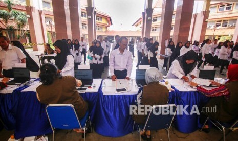 Peserta ujian Calon Pegawai Negeri Sipil (CPNS) Kota Tangerang melakukan pendaftaran sebelum memasuki ruangan ujian di Pusat Pemerintahan Kota Tangerang, Kota Tangerang, Banten, Kamis (20/2/2020).