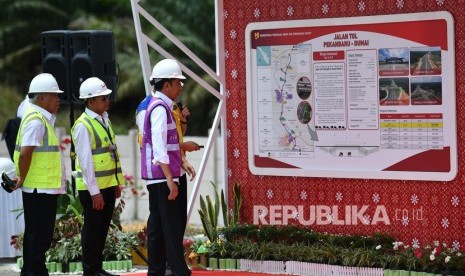 Presiden Joko Widodo (kanan) didampingi Menteri PUPR Basuki Hadimuljono (kiri) dan Dirut PT Hutama Karya (Persero) Bintang Perbowo (tengah) melihat data tentang progres pembangunan Jalan Tol Ruas Pekanbaru-Dumai di Rumbai, Pekanbaru, Riau, Jumat (21/2/2020). (Antara/Sigid Kurniawan )