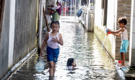 Anak anak bermain di banjir yang menggenangi Desa Kedungbanteng, Tanggulangin, Sidoarjo, Jawa Timur