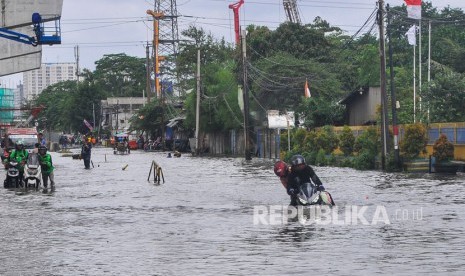 Sejumlah pengendara motor menerobos banjir di Pulogadung, Jakarta Timur, Minggu (23/2/2020). 