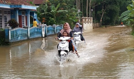 Sejumlah kendaraan memaksa melintas di jalanan yang terendam banjir di Desa Tanjungsari, Kecamatan Sukaresik, Kabupaten Tasikmalaya, Ahad (23/2). 