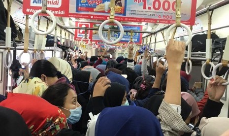 Penumpang commuter line. Anak kereta menerapkan jurusnya masing-masing untuk mengantisipasi corona di KRL.