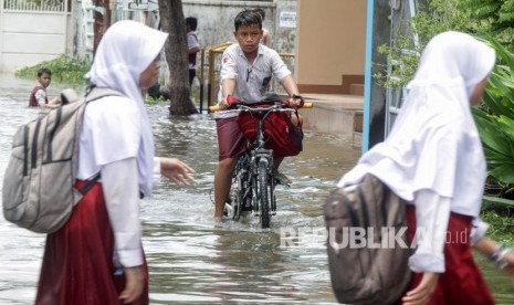 Siswa menerobos banjir yang merendam kawasan Sidokare, Sidoarjo, Jawa Timur