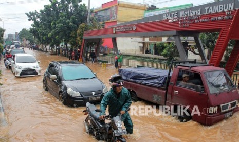 Sejumlah pengendara menerobos banjir di Jl. Sultan Hasanudin yang banjir di Tambun, Kabupaten Bekasi, Jawa Barat, Selasa (25/2/2020). 