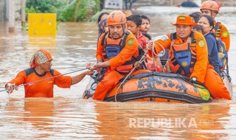 Petugas Basarnas mengevakuasi warga terdampak banjir di Desa Purwasari, Karawang, Jawa Barat, Selasa (25/2/2020).