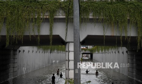 Anak-anak bermain air di underpass Jalan Angkasa yang terendam banjir, Kemayoran, Jakarta Pusat, Selasa (25/2/2020). 