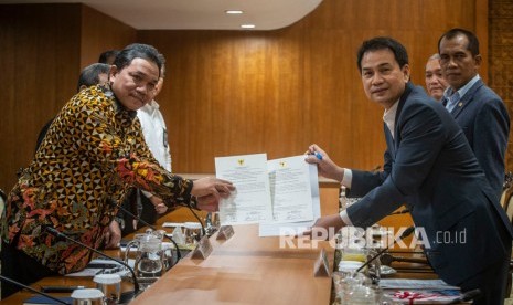 Wakil Ketua DPR Azis Syamsuddin (kanan) bersama Anggota III BPK Achsanul Qosasi (kiri) menunjukkan berita acara penyerahan laporan hasil pemeriksaan kinerja atas efektivitas penerapan regulasi dalam menunjang pelaksanaan tugas dan fungsi LPP RRI dan TVRI tahun anggaran 2017 sampai dengan Semester I/2019, di Kompleks Parlemen, Senayan, Jakarta, Rabu (26/2/2020). 