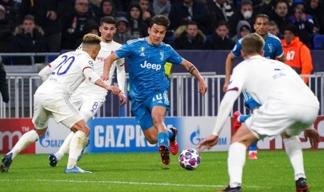  Pemain Juventus Paulo Dybala berusah melewati barisan pertahanan Lyon pada leg pertama babak 16 besar Liga Champions 2019/2020 di Stadion Groupama, Lyon, Kamis (27/2) dini hari WIB. 