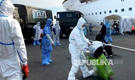 Petugas kesehatan bersiap menyemprotkan cairan disinfektan kepada WNI ABK Diamond Princess dan barang bawaan saat turun dari kapal di Yokohama, Jepang, Ahad (2/3/3030). 