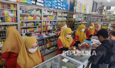 Pegawai apotek mengenakan masker saat melayani konsumen. Harga masker di beberapa kabupaten/kota di Maluku Utara naik karena diborong warga. Ilustrasi.