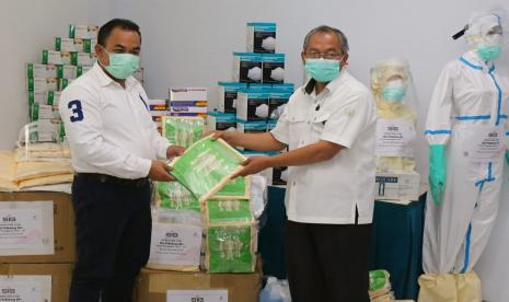 Kepala Departemen CSR SIG, Edy Saraya (kiri) menyerahkan bantuan APD dan Alkes bagi tenaga medis di Rumah Sakit Semen Gresik (RSSG) yang diterima oleh Kepala RSSG, dr Muchdor SpB FINACs.