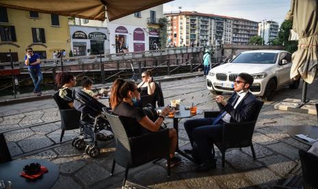 Sejumlah orang menikmati makanan di sebuah restoran di distrik Trastevere selama fase dua masa pemulihan pandemi Covid-19, Roma, Italia, Senin (18/5). Italia secara bertahap mencabut kebijakan lockdown yang diterapkan untuk membendung penyebaran COVID-19. 