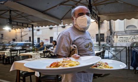 Sejumlah orang menikmati makanan di sebuah restoran di Italia