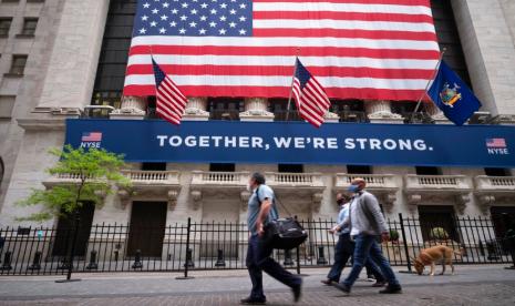 Orang berjalan melintasi gedung New York Stock Exchange, Selasa (26/5).