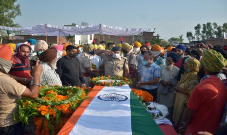 Rusia Harap India-China Bisa Redakan Ketegangan. Foto: Seorang perwira polisi Punjab (C) memberi hormat ketika ia membayar upeti di peti mati prajurit India Satnam Singh, yang terbunuh dalam bentrokan dengan tentara Cina di Ladakh, selama upacara pemakamannya di desa asli Bhojraj, dekat Gurdaspur, India, 18 Juni 2020 .