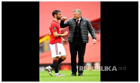 Pelatih Manchester United Ole Gunnar Solskjaer salam siku dengan pemain Manchester United Bruno Fernandes usai laga Manchester United melawan Bournemouth di Stadion Old Trafford, Sabtu (4/7). 