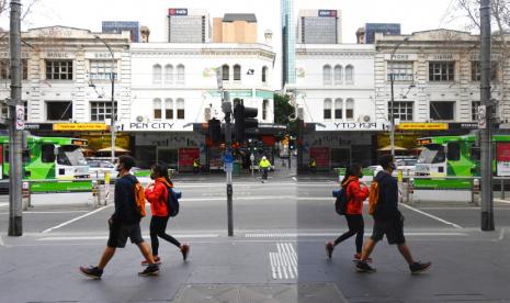 Pejalan kaki bermasker melintas di psat bisnis Melbourne, Australia, Rabu (22/7). Karantina wilayah dinilai berhasil menekan infeksi Covid-19 di Victoria. Ilustrasi.