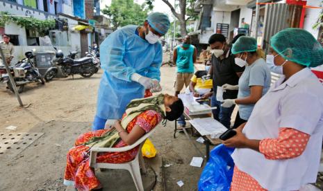 Petugas melakukan uji usap (swab test) pada seorang warga di Ahmedabad, India, Ahad (6/9).  India mencatat 4 juta kasus Covid-19 dan menjadikannya negara kedua dengan kasus tertinggi di dunia.