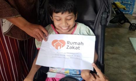 Relawan Rumah Zakat menyalurkan bantuan berupa satu unit stroller kepada Siti Aura Arfa (15 tahun) di tempat tinggalnya yang terletak di Jalan Tangkul 1, Medan Tembung.