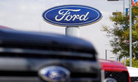 Mobil melintas di depan diler Ford di Denver, Amerika Serikat. Dampak dari krisis semikonduktor global pada industri otomotif membuat Ford Motor Co harus memangkas produksinya.