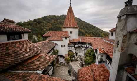 Orang berjalan di taman dalam Kastil Bran atau yang terkenal dengan nama Kastil Drakula di Transylvania, Rumania. Pemerintah Rumania menawarkan wisata vaksinasi Covid-19 di Kastil Drakula