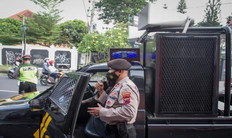 Polisi menyosialisasikan Penerapan Pembatasan Kegiatan Masyarakat (PPKM) Darurat saat berpatroli keliling kota di Solo, Jawa Tengah, Jumat (2/7/2021). Patroli keliling kota yang diikuti tim gabungan Polisi, TNI dan Satpol PP tersebut untuk menyosialisasikan penerapan PPKM Darurat pada 3-20 Juli 2021 kepada masyarakat agar patuh dan disiplin menjalaninya.