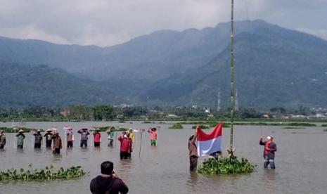   Petani Rawapening yang tergabung dalam Forum Petani Rawa Pening Bersatu (FPRPB) menggelar upacara bendera memperingati HUT Kemerdekaan RI ke-76 di atas lahan pertanian mereka yangvtergenang elevasi air danau Rawapening, di Desa Bejalen, Kecamatan Ambarawa, Kabupaten Semarang, Selasa (17/8).