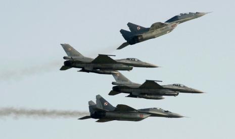 Angkatan Udara Polandia menerbangkan pesawat buatan Rusia MiG-29 (atas) dan jet tempur F-16 di Radom, Polandia, 27 Agustus 2022. 