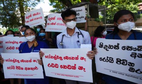 Dokter pemerintah Sri Lanka memprotes pemerintah di dekat rumah sakit nasional di Kolombo, Sri Lanka, Rabu, 6 April 2022. Selama beberapa bulan, warga Sri Lanka mengalami antrean panjang untuk membeli bahan bakar, gas untuk memasak, makanan dan obat-obatan, yang sebagian besar datang dari luar negeri. Plakat bertuliskan 