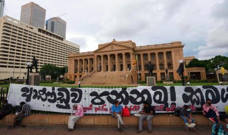 Warga Sri Lanka duduk di dekat pagar kantor presiden. Sri Lanka menerima kiriman pertama paket bantuan kemanusiaan senilai 16 juta dolar AS dari India