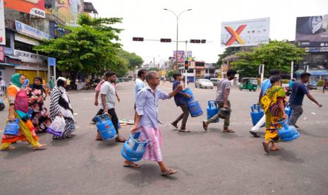 Warga Sri Lanka buru-buru membeli gas untuk memasak menyusul kedatangan gas untuk memasak di sebuah pusat distribusi di Kolombo, Sri Lanka, Minggu, 8 Mei 2022. Para diplomat dan kelompok hak asasi menyatakan keprihatinan Sabtu setelah Presiden Sri Lanka Gotabaya Rajapaksa menyatakan keadaan darurat dan polisi menggunakan kekerasan terhadap pengunjuk rasa damai di tengah krisis ekonomi terburuk negara dalam memori baru-baru ini.