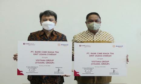 Head of Sharia Consumer CIMB Niaga Bung Aldilla (kanan) dan CEO Visitama Group Muhammad Emiriza (kiri) menunjukkan mock-up kerja sama usai Penandatanganan Memorandum of Understanding antara CIMB Niaga Syariah dengan Syaamil Group di Bandung pekan lalu. 