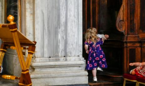 Seorang anak bermain dengan boneka di dalam St Mary Major Basilica, di Roma, Selasa, 31 Mei 2022. Italia tengah menghadapi tren penurunan angka kelahiran.