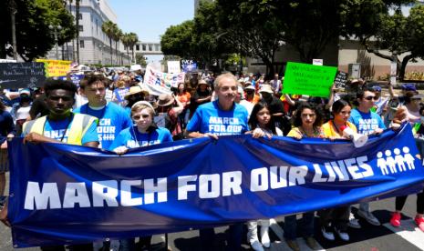 Pengacara Kota Los Angeles dan mantan calon walikota Mike Feuer, tengah, berbaris bersama dengan pemrotes saat mereka meneriakkan dan melambaikan tanda di pusat kota Los Angles selama demonstrasi March for Our Lives, Sabtu, 11 Juni 2022. Ribuan orang berunjuk rasa di seluruh Amerika Serikat pada hari Sabtu dalam dorongan baru untuk tindakan pengendalian senjata setelah penembakan massal baru-baru ini yang mematikan yang menurut para aktivis harus memaksa Kongres untuk bertindak. Presiden AS Joe Biden resmikan UU Kekerasan Senjata terbaru akibat penembakan massal.