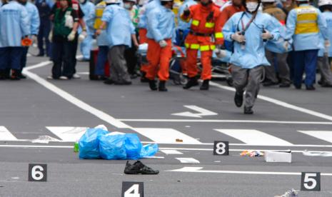 Sepatu korban ditinggalkan di jalan ketika penyelamat dari Departemen Kepolisian Metropolitan Tokyo bekerja di distrik Akihabara Tokyo setelah seorang pria menabrakkan truk ke kerumunan pembeli, melompat keluar dan melakukan penusukan di distrik elektronik top Tokyo pada 8 Juni. 2008. Jepang pada Selasa, 26 Juli 2022 mengeksekusi seorang pria yang dihukum karena membunuh tujuh orang dalam amukan 2008 di distrik elektronik Akihabara Tokyo, menteri kehakiman mengumumkan.